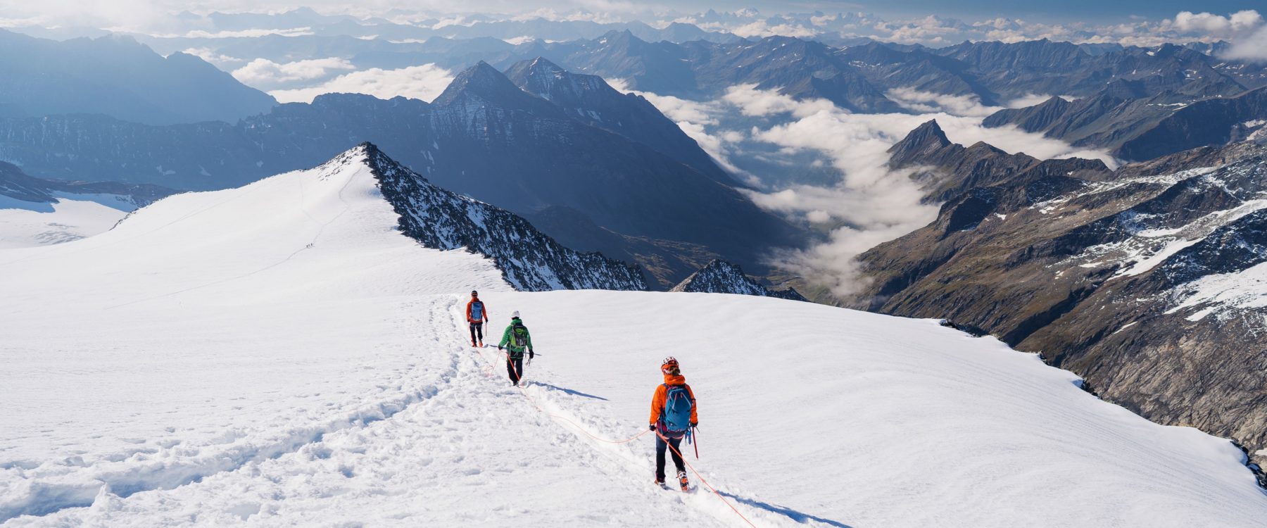 Group of people hiking over top of mountain