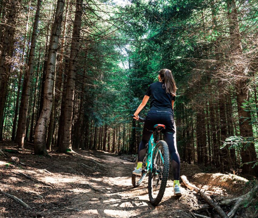 woman riding bike through forest